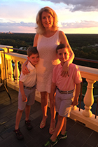 Dr. Huger smiles with her twin boys on a balcony